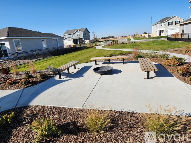 A park with a circular bench in the middle of a concrete path.