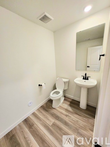 A room with carpeted floor and two windows.