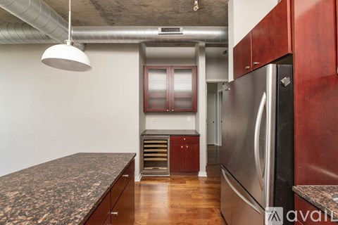 A kitchen with a granite countertop and stainless steel appliances.
