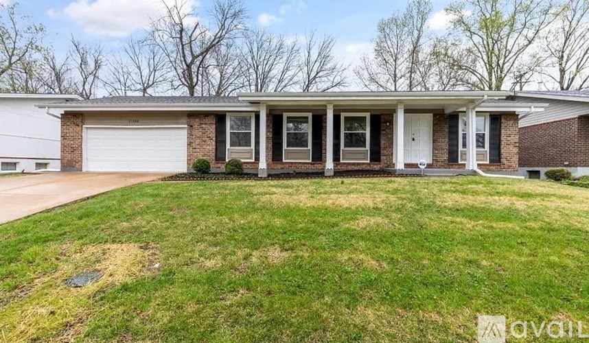 A house with a white garage door and a brick facade.
