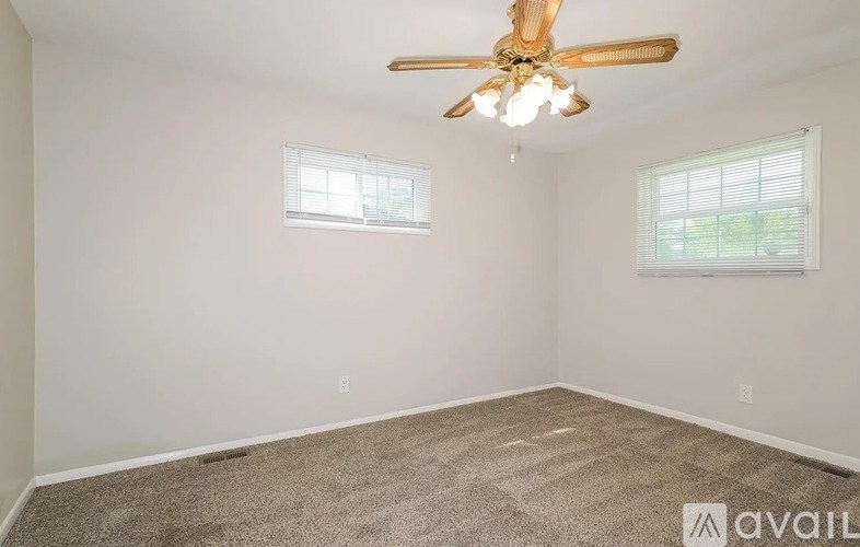 A room with a ceiling fan and wooden flooring.
