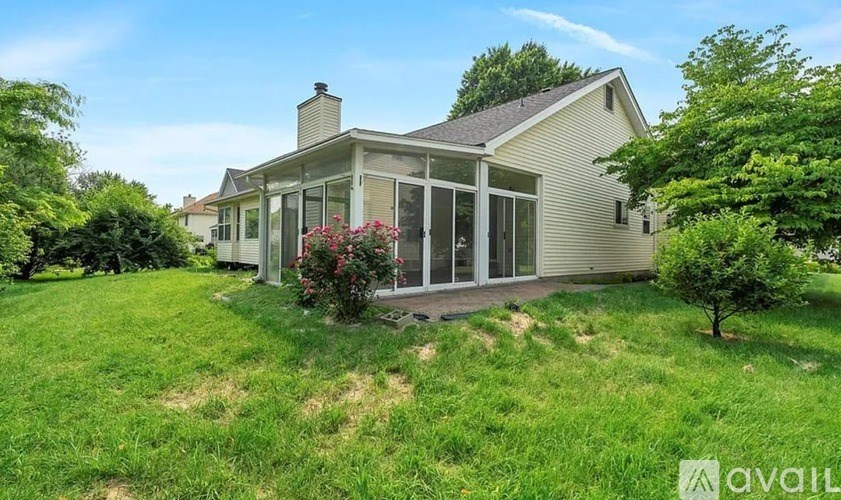A house with a large front yard and a tree.