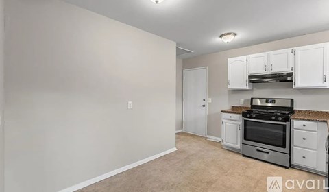 A kitchen with white cabinets and a stove top oven.