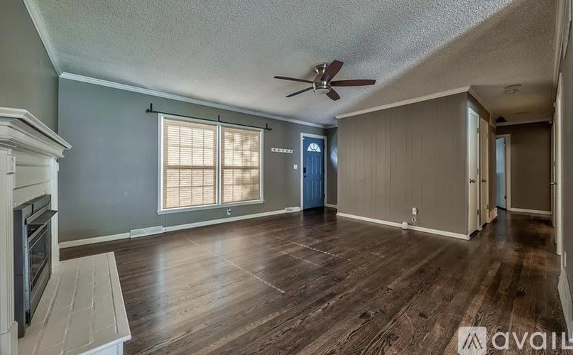 A room with a ceiling fan and wooden flooring.