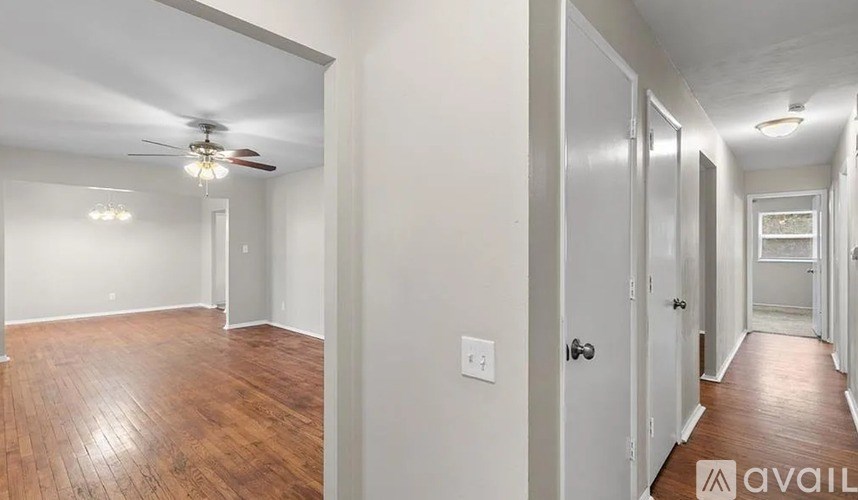 A hallway with a fan and light fixture on the ceiling.