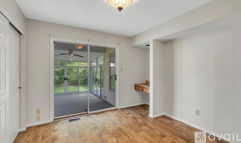 A room with a ceiling fan and a window showing an outdoor view.