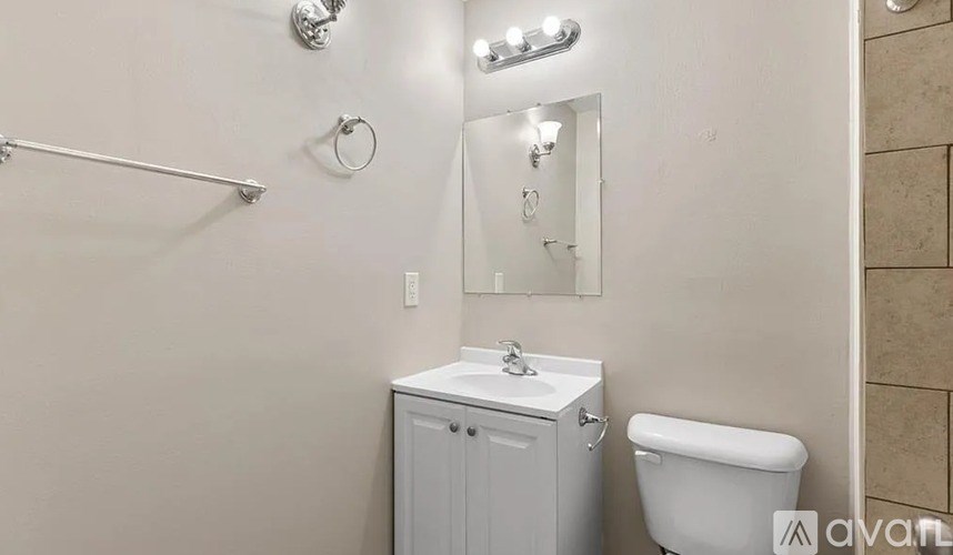 A white bathroom with a toilet, sink, and shower.