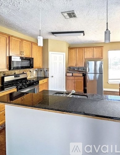 A kitchen with wooden cabinets and a black countertop.