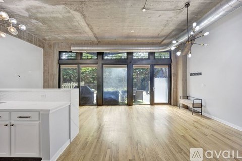 A kitchen with white cabinets and a wooden floor.