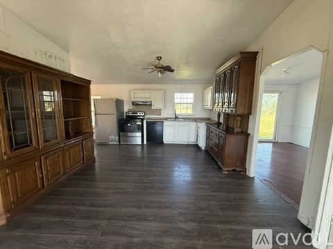 A spacious kitchen with wooden cabinets and a ceiling fan.
