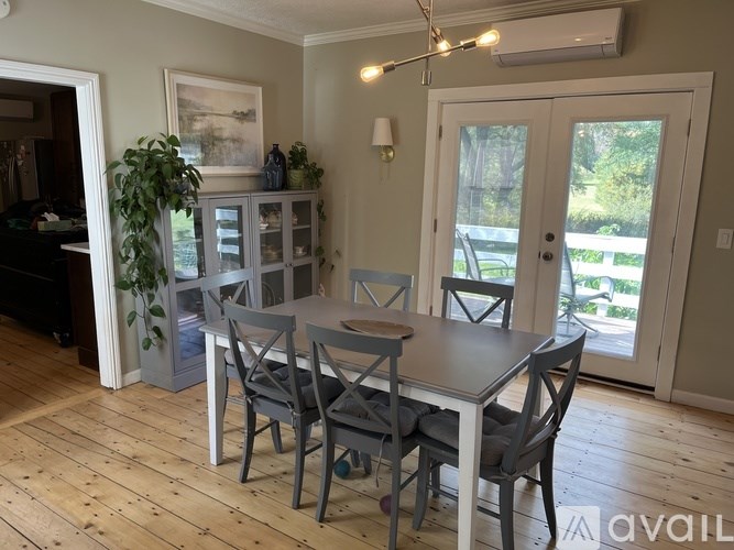 A dining room with a wooden table and chairs.