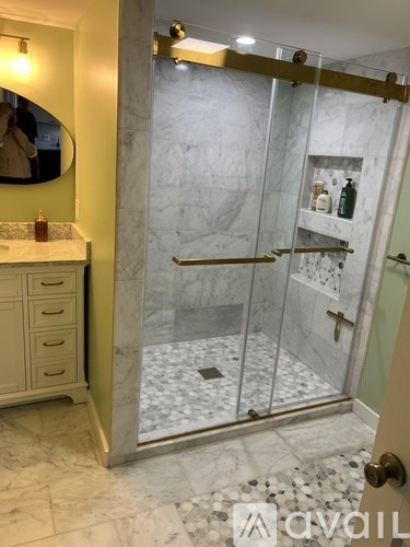 A bathroom with a marble floor and a walk-in shower.