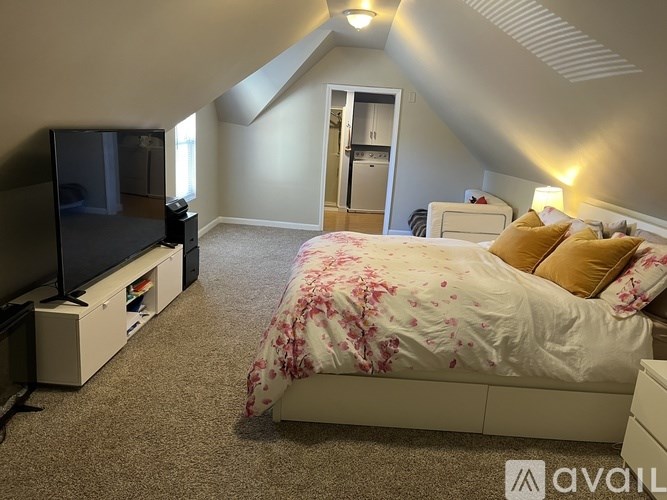 A bedroom with a bed, a television, and a cabinet.