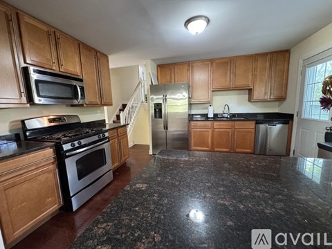 A kitchen with wooden cabinets and granite countertops.