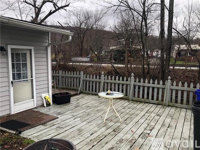 A small white table is on a wooden deck.