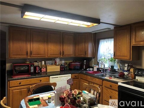 A kitchen with wooden cabinets and a table with a cake on it.
