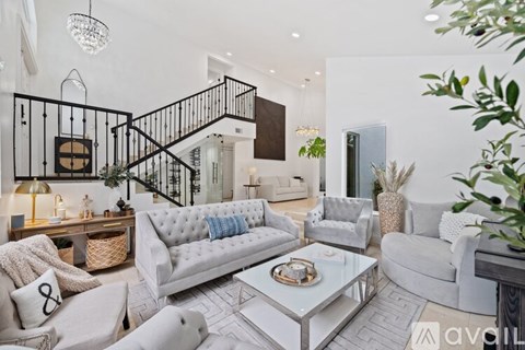 A living room with a white couch and a glass coffee table.