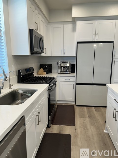A kitchen with white cabinets and a black stove top.