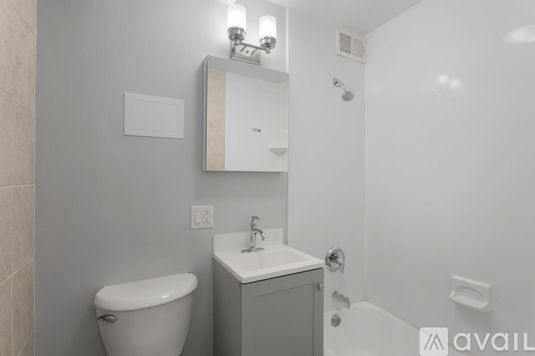 A bathroom with a toilet, sink, and mirror.