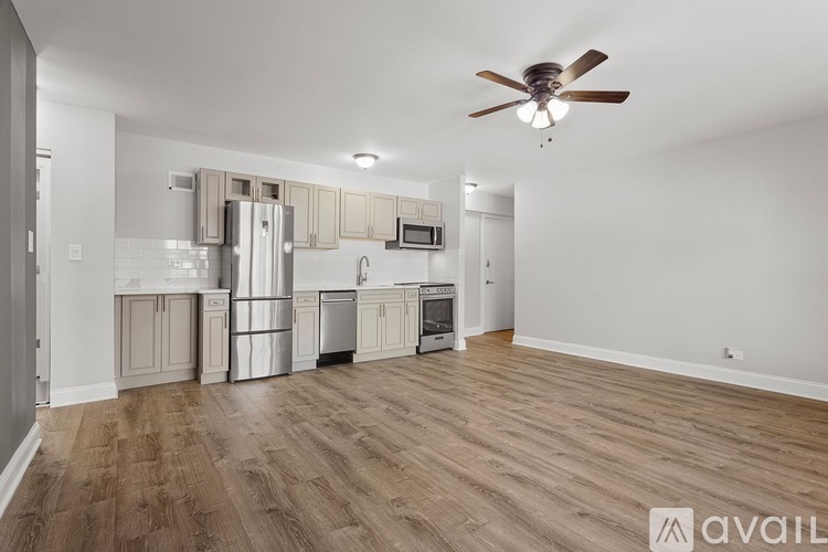 A spacious kitchen with wooden floors and a ceiling fan.