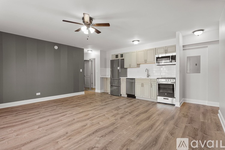 A spacious kitchen with wooden flooring and modern appliances.