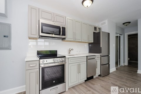 A kitchen with a stove, oven, microwave, and refrigerator.