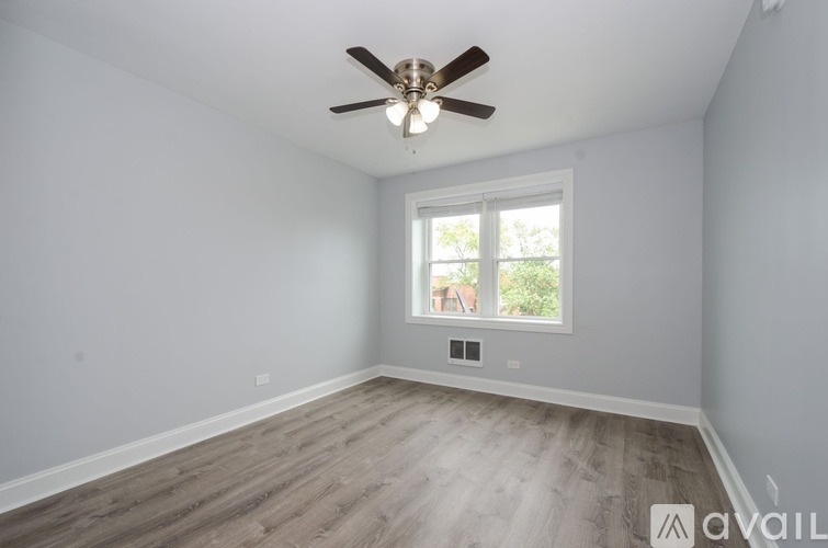 A room with a ceiling fan and a window.