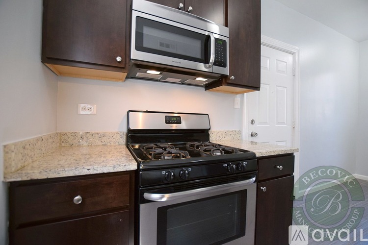 A modern kitchen with a stove top oven and microwave above it.