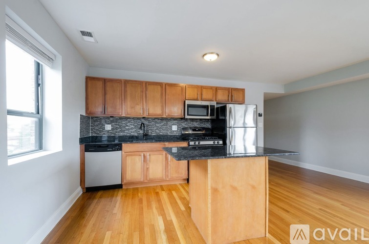 A kitchen with wooden cabinets and a black countertop.