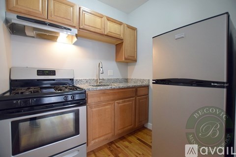 A kitchen with a stove, refrigerator, and cabinets.