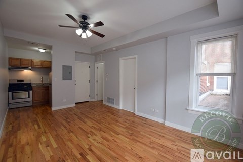 A room with wooden floors and a ceiling fan.