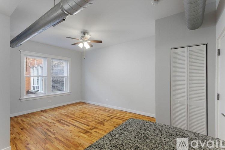A room with a ceiling fan and a window with blinds.