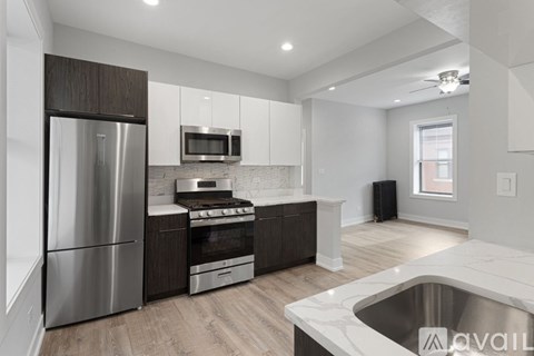 A modern kitchen with stainless steel appliances and wooden cabinets.