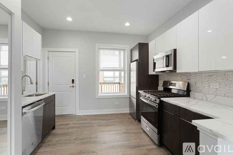 A modern kitchen with dark wood floors and white cabinetry.