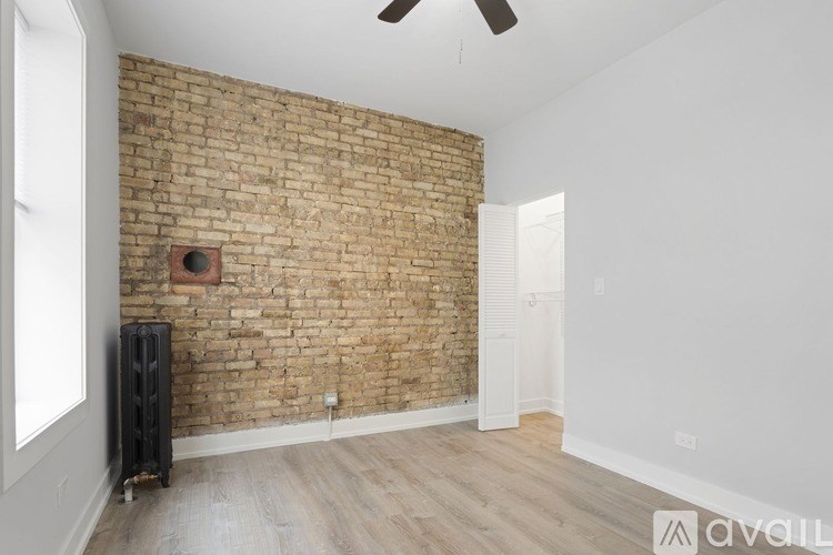 A room with a brick wall and a ceiling fan.