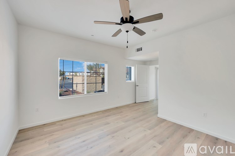 A room with a ceiling fan and a window with blinds.