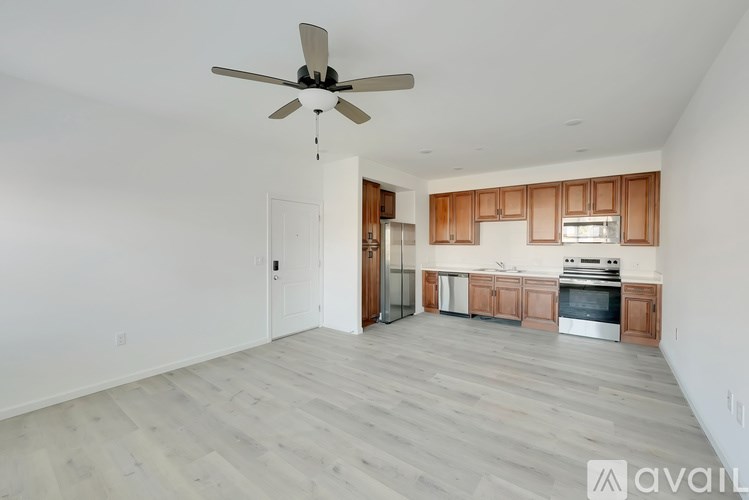 A spacious kitchen with wooden cabinets and a ceiling fan.