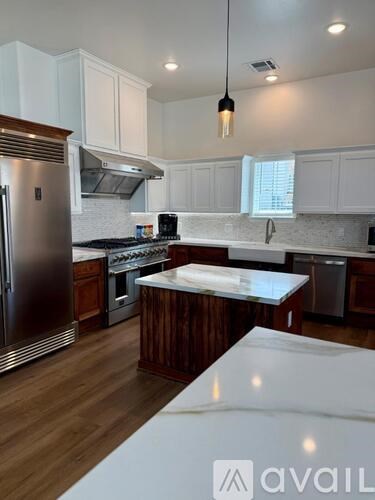 A modern kitchen with wooden cabinets and stainless steel appliances.