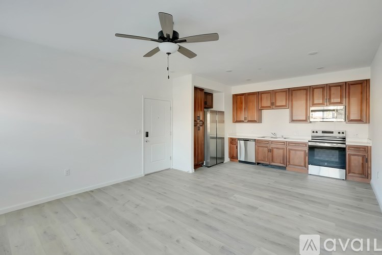 A spacious kitchen with wooden cabinets and a stainless steel refrigerator.