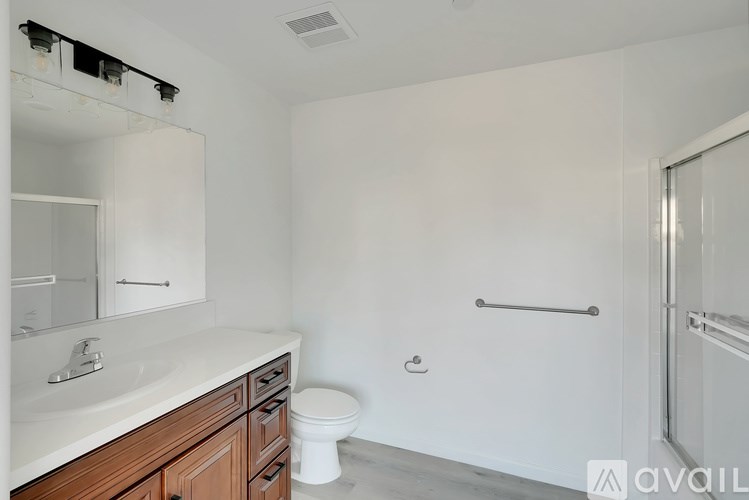 A bathroom with a toilet, sink, and mirror.