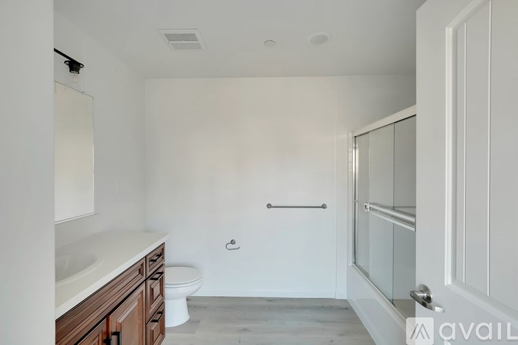A white bathroom with a toilet, sink, and shower.