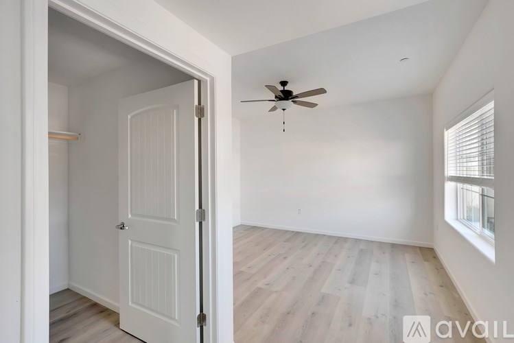 A room with a ceiling fan and a door.