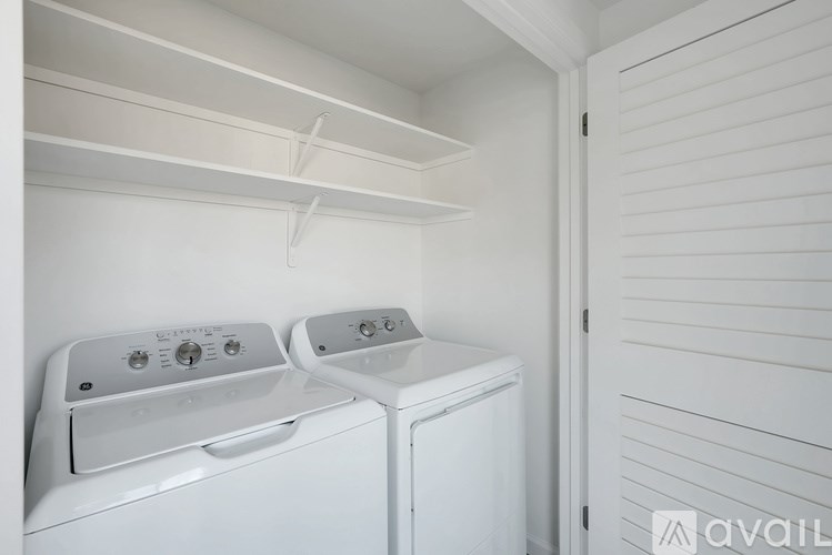 Two white front loading washing machines in a laundry room.
