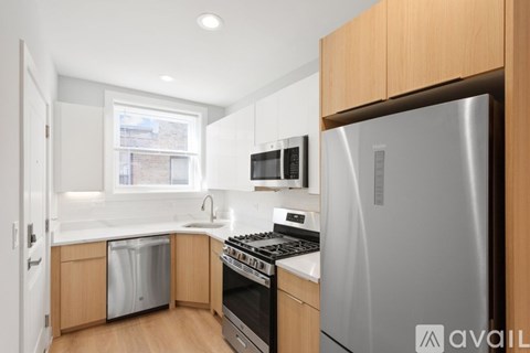 A kitchen with a refrigerator, stove, and microwave.