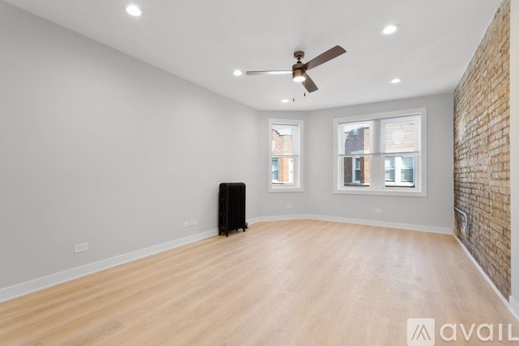 A room with a ceiling fan and wooden flooring.