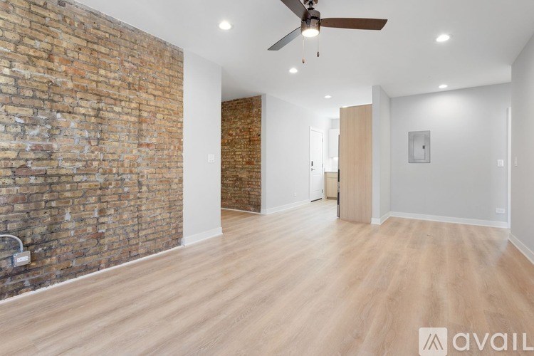A room with a brick wall and wooden flooring.