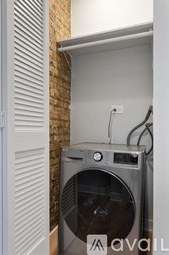 A washing machine is sitting in a small laundry room.