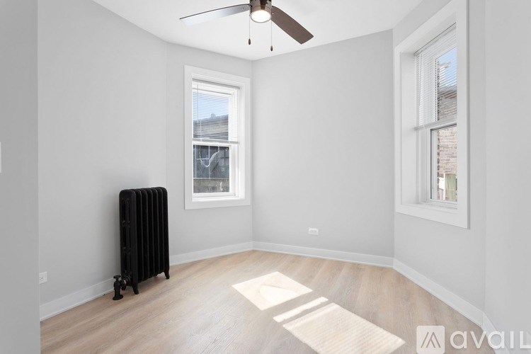 A room with a ceiling fan and a radiator on the floor.