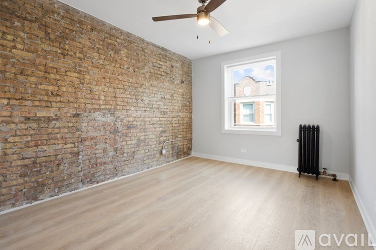 A room with a brick wall and wooden floor.