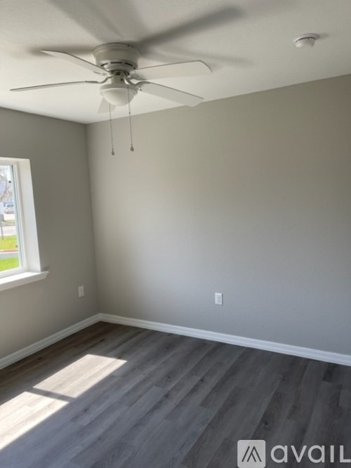 A room with a ceiling fan and a window.